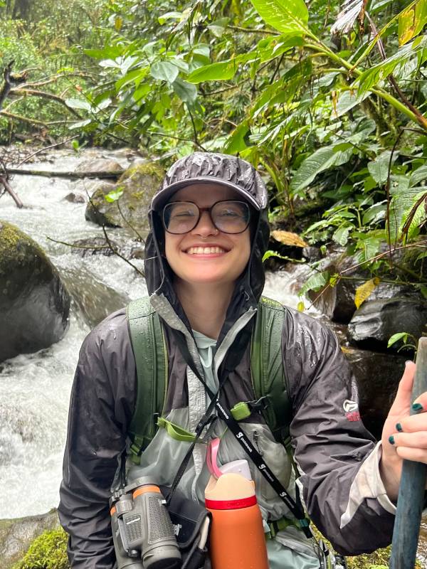 Dee Phillips stands by a stream in the cloud forests
